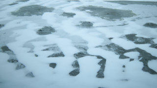 Snow covers frozen lake stock footage